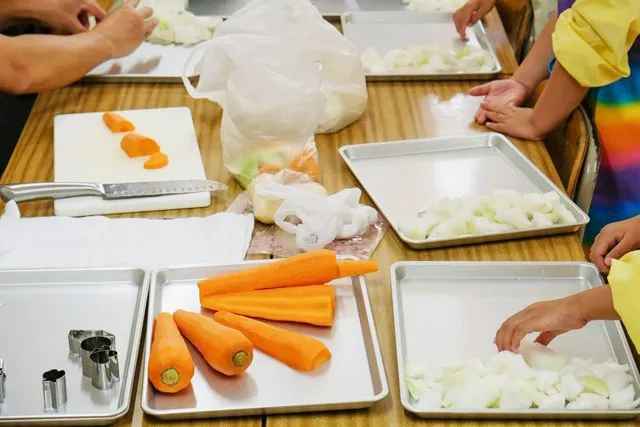 子どもたちが野菜を切って調理準備する授業風景